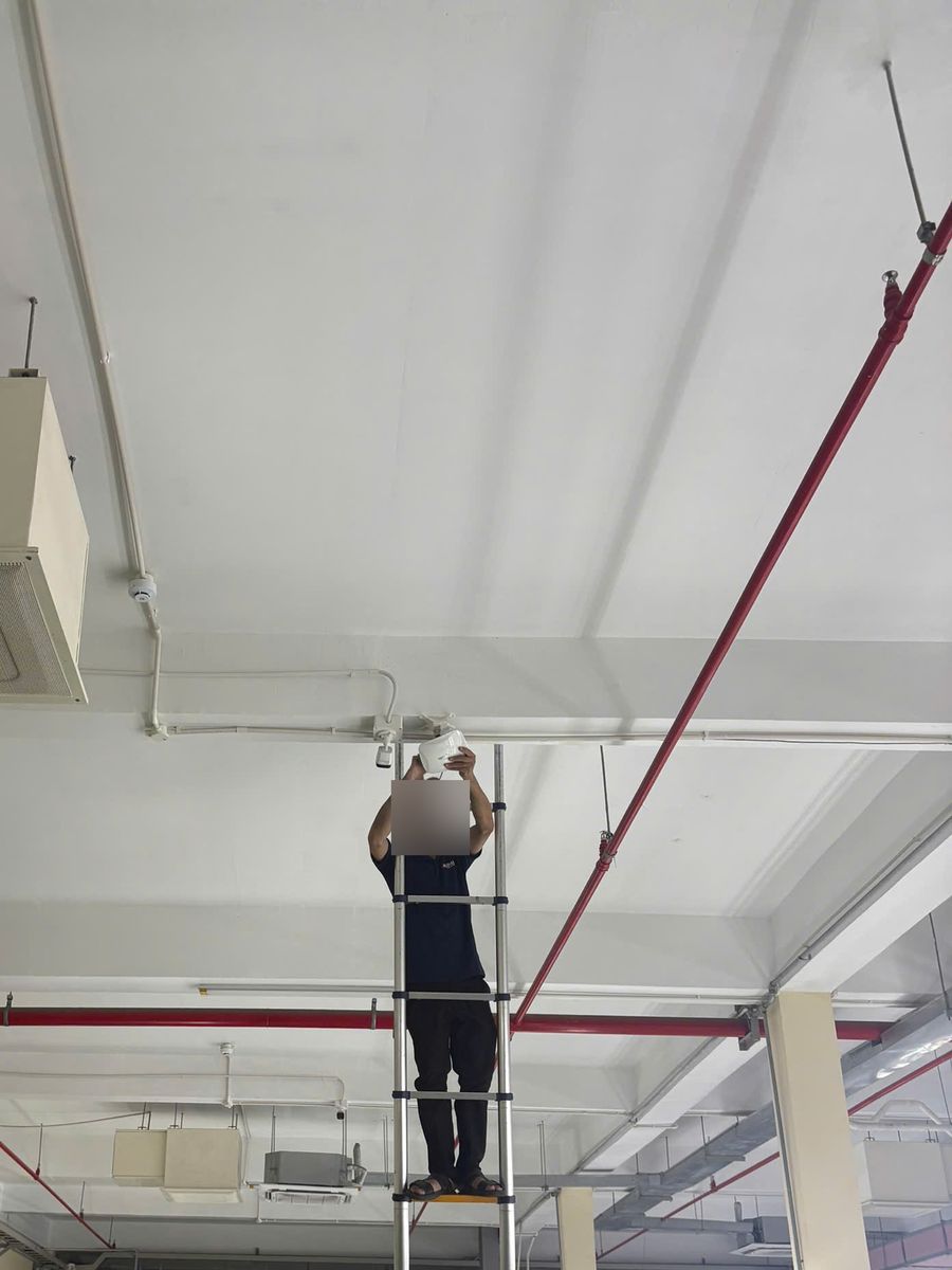 Lắp đặt thiết bị Wi‑Fi và camera trên trần nhà xưởng bằng thang