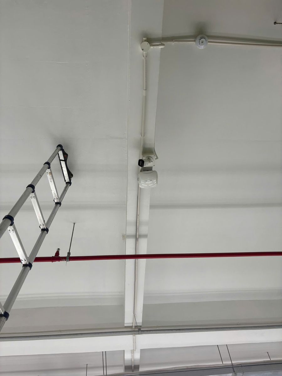 Thiết bị phát Wi‑Fi và camera lắp trên dầm trần nhà xưởng